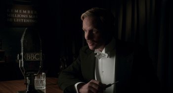 Movie still from “Vita & Virginia” (2018), directed by Chanya Button – A man sitting at a table in front of a glass of water; Close Up shot, Over the shoulder angle