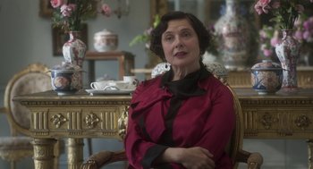 Movie still from “Vita & Virginia” (2018), directed by Chanya Button – An older woman sitting in front of a dining room table; Close Up shot, Over the shoulder angle