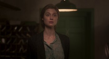 Movie still from “Vita & Virginia” (2018), directed by Chanya Button – A woman standing in a room with a light in the background; Close Up shot, Over the shoulder angle