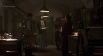 Movie still from “Vita & Virginia” (2018), directed by Chanya Button – A group of people standing around in a room; Wide shot, Low angle