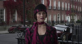 Movie still from “Vita & Virginia” (2018), directed by Chanya Button – A woman wearing a black and pink coat and a black hat; Medium shot, Over the shoulder angle