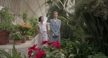 Movie still from “Vita & Virginia” (2018), directed by Chanya Button – Two women standing next to each other in a greenhouse; Medium shot, Low angle