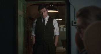 Movie still from “Vita & Virginia” (2018), directed by Chanya Button – A man standing in a room with his hands in his pockets; Medium shot, Over the shoulder angle