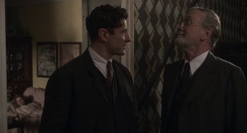 Movie still from “Vita & Virginia” (2018), directed by Chanya Button – A man in a suit talking to another man in a suit; Medium shot, Over the shoulder angle