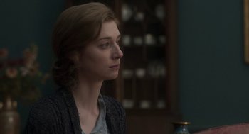 Movie still from “Vita & Virginia” (2018), directed by Chanya Button – A woman sitting in front of a table looking to her left; Close Up shot, Over the shoulder angle