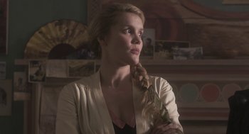 Movie still from “Vita & Virginia” (2018), directed by Chanya Button – A beautiful woman with long blonde hair wearing a white shirt; Close Up shot, Over the shoulder angle