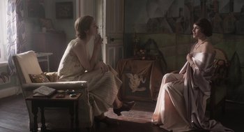 Movie still from “Vita & Virginia” (2018), directed by Chanya Button – A woman sitting on a chair next to another woman; Medium shot, Over the shoulder angle
