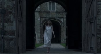 Movie still from “Vita & Virginia” (2018), directed by Chanya Button – A woman in a long white dress walking down a walkway; Wide shot, Low angle