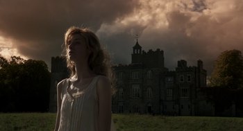 Movie still from “Vita & Virginia” (2018), directed by Chanya Button – A woman standing in front of an old castle; Medium shot, Low angle
