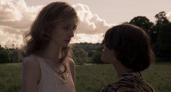 Movie still from “Vita & Virginia” (2018), directed by Chanya Button – A woman and a man standing next to each other in a field; Close Up shot, Low angle