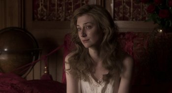 Movie still from “Vita & Virginia” (2018), directed by Chanya Button – A woman sitting in a chair looking at the camera; Close Up shot, Over the shoulder angle