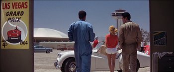 Movie still from “Viva Las Vegas” (1964), directed by George Sidney – A group of people standing next to an antique car; Wide shot, Low angle