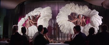 Movie still from “Viva Las Vegas” (1964), directed by George Sidney – A group of people sitting at a table in front of a stage; Wide shot, Low angle