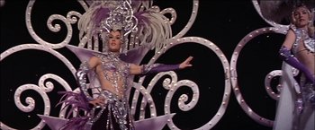 Movie still from “Viva Las Vegas” (1964), directed by George Sidney – A person in a costume on a stage; Medium shot, Low angle