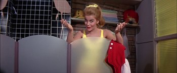 Movie still from “Viva Las Vegas” (1964), directed by George Sidney – A woman in a yellow top is holding a red cloth; Medium shot, Low angle