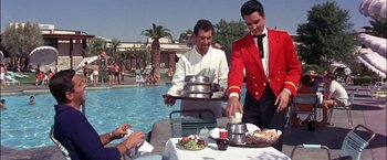 Movie still from “Viva Las Vegas” (1964), directed by George Sidney – A man in a red jacket serves food to a man in a white shirt; Medium shot, Over the shoulder angle