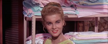 Movie still from “Viva Las Vegas” (1964), directed by George Sidney – A beautiful woman with red hair standing next to a pile of folded towels; Close Up shot, Low angle
