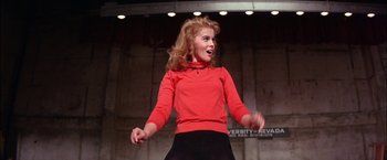 Movie still from “Viva Las Vegas” (1964), directed by George Sidney – A woman in a red shirt and black skirt is on stage; Medium shot, Low angle