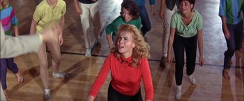 Movie still from “Viva Las Vegas” (1964), directed by George Sidney – A group of young people standing on a basketball court; Medium shot, High angle