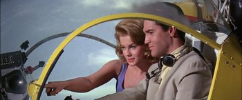 Movie still from “Viva Las Vegas” (1964), directed by George Sidney – A man and a woman looking at each other in an airplane; Medium shot, Low angle