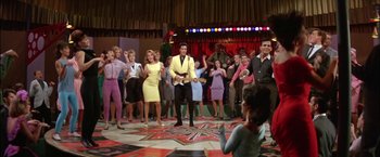 Movie still from “Viva Las Vegas” (1964), directed by George Sidney – A group of people standing in a room; Wide shot, Low angle