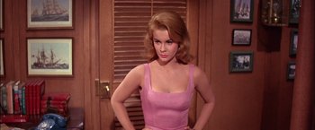 Movie still from “Viva Las Vegas” (1964), directed by George Sidney – A woman in a pink dress standing in front of a wooden door; Medium shot, Low angle