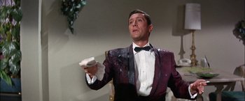 Movie still from “Viva Las Vegas” (1964), directed by George Sidney – A man in a suit and tie holding a remote control; Medium shot, Low angle