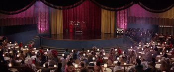 Movie still from “Viva Las Vegas” (1964), directed by George Sidney – People are sitting in chairs in front of a stage; Extreme Wide shot, High angle