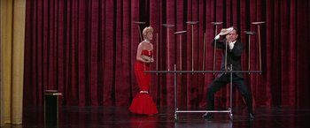 Movie still from “Viva Las Vegas” (1964), directed by George Sidney – A woman in a red dress standing in front of a ping pong table; Wide shot, Low angle
