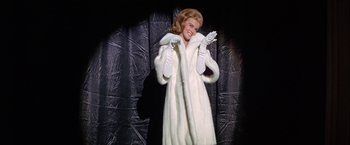 Movie still from “Viva Las Vegas” (1964), directed by George Sidney – A woman in a white fur coat and white gloves; Medium shot, Low angle