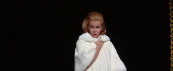 Movie still from “Viva Las Vegas” (1964), directed by George Sidney – A woman in a white fur coat is posing for the camera; Close Up shot, Low angle