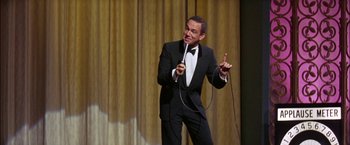 Movie still from “Viva Las Vegas” (1964), directed by George Sidney – A man in a tuxedo is holding a microphone; Medium shot, Low angle