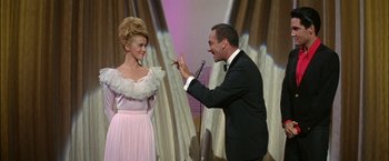 Movie still from “Viva Las Vegas” (1964), directed by George Sidney – A man in a suit and a woman in a pink dress; Medium shot, Low angle