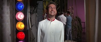 Movie still from “Viva Las Vegas” (1964), directed by George Sidney – A man in a white suit laughing with people in the background; Medium shot, Low angle