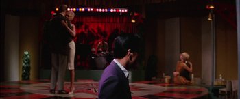 Movie still from “Viva Las Vegas” (1964), directed by George Sidney – A man wearing a suit and tie standing in front of an audience; Wide shot, Low angle