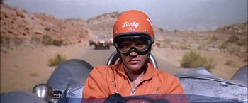 Movie still from “Viva Las Vegas” (1964), directed by George Sidney – A person in a car wearing an orange helmet; Close Up shot, Low angle