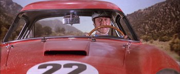 Movie still from “Viva Las Vegas” (1964), directed by George Sidney – A man sitting in the driver's seat of an old race car; Close Up shot, Low angle