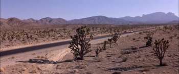 Movie still from “Viva Las Vegas” (1964), directed by George Sidney – A car driving down a road in the middle of the desert; Extreme Wide shot, High angle