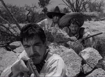 Movie still from “Viva Zapata!” (1952), directed by Elia Kazan – A group of men with guns in a rocky area; Medium shot, Low angle