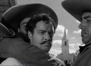 Movie still from “Viva Zapata!” (1952), directed by Elia Kazan – A man is hugging another man in front of a church; Close Up shot, Low angle