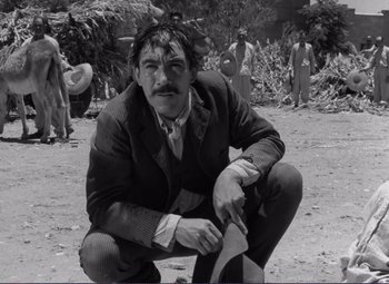 Movie still from “Viva Zapata!” (1952), directed by Elia Kazan – A man kneeling on the ground in front of a group of people; Medium shot, Low angle