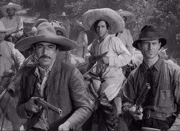 Movie still from “Viva Zapata!” (1952), directed by Elia Kazan – A black and white photo of a group of men with guns; Medium shot, Low angle