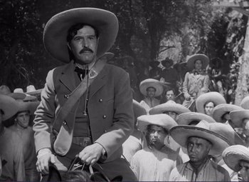 Movie still from “Viva Zapata!” (1952), directed by Elia Kazan – An old photo of a man on a horse in front of a crowd; Medium shot, Low angle