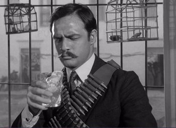 Movie still from “Viva Zapata!” (1952), directed by Elia Kazan – A black and white photo of a man holding a glass of whiskey; Close Up shot, Low angle