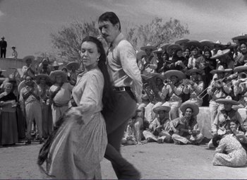 Movie still from “Viva Zapata!” (1952), directed by Elia Kazan – A man and a woman dancing in front of a crowd; Wide shot, Low angle