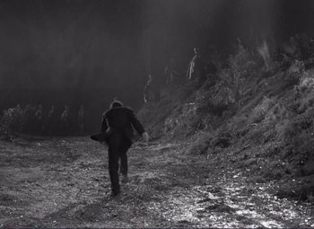 Movie still from “Viva Zapata!” (1952), directed by Elia Kazan – A man is walking through the mud with a frisbee; Extreme Wide shot, High angle