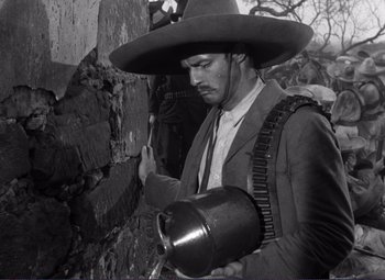 Movie still from “Viva Zapata!” (1952), directed by Elia Kazan – A man in a cowboy hat holding a rifle; Medium shot, Low angle