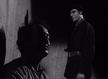 Movie still from “Viva Zapata!” (1952), directed by Elia Kazan – Two men standing next to each other in front of a wall; Medium shot, Low angle