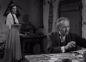 Movie still from “Viva Zapata!” (1952), directed by Elia Kazan – An old photo of a man and a woman sitting at a table; Medium shot, Low angle