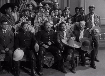 Movie still from “Viva Zapata!” (1952), directed by Elia Kazan – A group of men sitting on top of a couch; Wide shot, High angle
